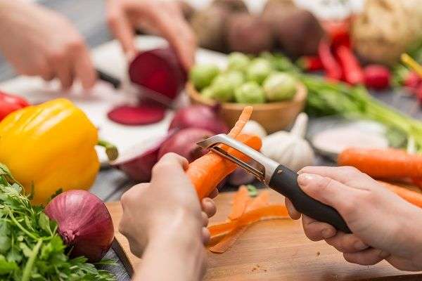 Hands peeling vegetables