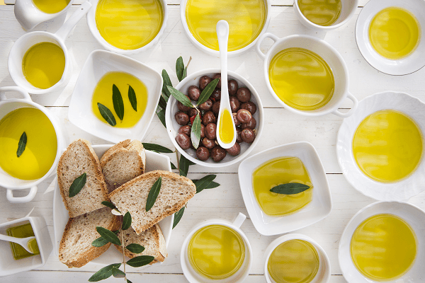 Dishes with extra virgin olive oil, bread and olive leaves