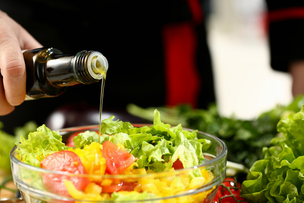 Cook holds bottle in hand and trickles olive